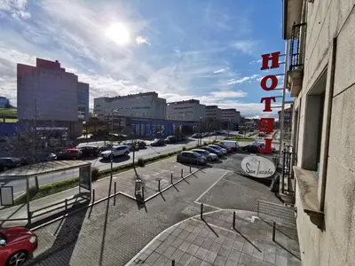 a parking lot with cars parked in a city at Hotel San Jacobo in Santiago de Compostela
