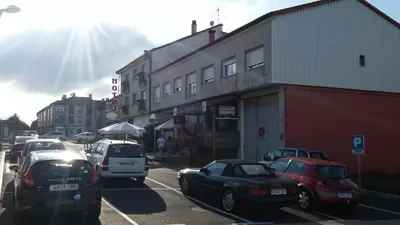 a street with cars parked in front of a building at Hotel San Jacobo in Santiago de Compostela