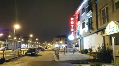 a city street at night with a hotel sign at Hotel San Jacobo in Santiago de Compostela