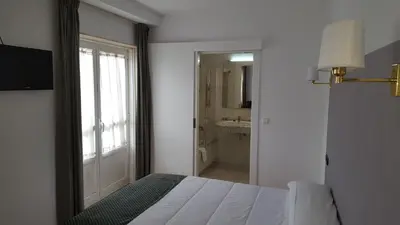 a bedroom with a bed and a bathroom with a mirror at Hotel San Jacobo in Santiago de Compostela