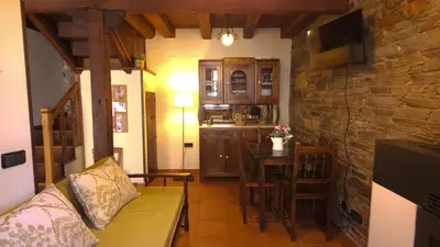a living room with a couch and a table and a kitchen at A Casoa II in Santa Eulalia de Oscos