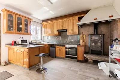 a kitchen with wooden cabinets and a stove at Casa Montellos in Betanzos