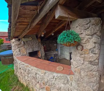 a stone house with a stone fireplace in a yard at Casa Montellos in Betanzos