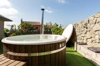 a hot tub in a yard with a surfboard at Casa Montellos in Betanzos