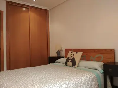 a bedroom with two beds and a wooden closet at Piso Estación Tren Ourense in Ourense