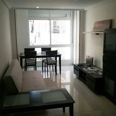 a living room with a couch and a table with chairs at Piso Estación Tren Ourense in Ourense