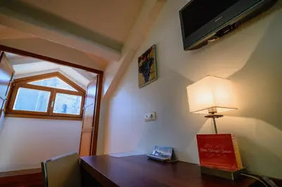 a room with a desk with a lamp and a television at Plaza Mayor in Villafranca del Bierzo