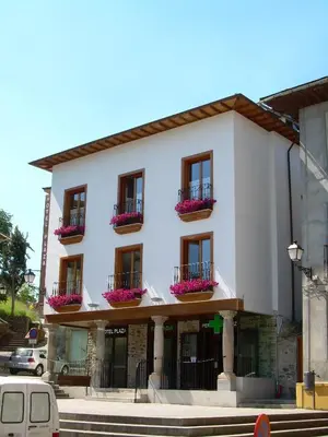 a white building with flower boxes on the windows at Plaza Mayor in Villafranca del Bierzo