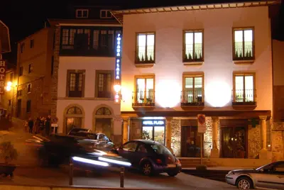 a city street with cars parked in front of a building at Plaza Mayor in Villafranca del Bierzo