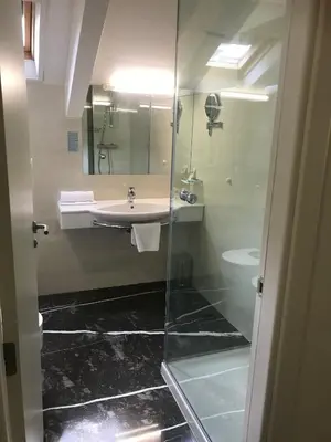 a bathroom with a sink and a glass shower at Plaza Mayor in Villafranca del Bierzo