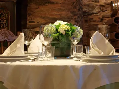a table with plates and glasses and a vase of flowers at Casa Brandariz in Santa Maria de Arzua