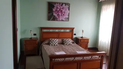 a bedroom with a wooden bed and two night stands at Casa Julia De Lozano in Rinlo