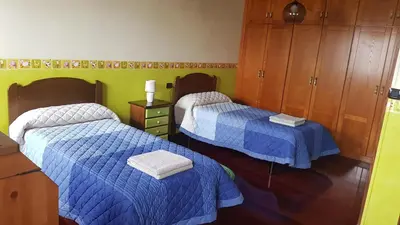 a bedroom with two beds and a dresser at Casa Julia De Lozano in Rinlo