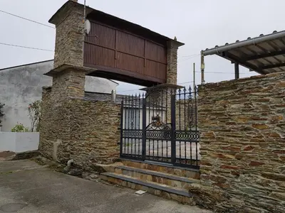 a stone building with a gate and a brick wall at Casa Julia De Lozano in Rinlo