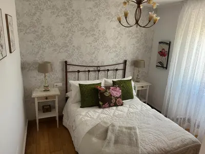 a bedroom with a bed with green and pink pillows at Charming house in Teo with balcony and parking included in Rua De Francos