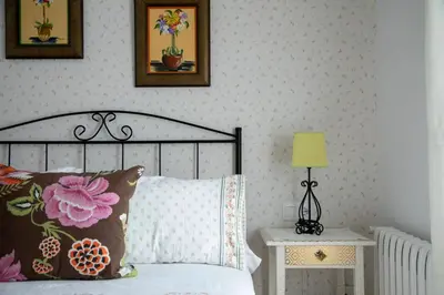 a bedroom with a bed with flowers on the wall at Charming house in Teo with balcony and parking included in Rua De Francos