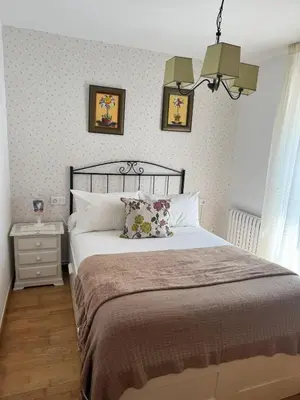 a bedroom with a large bed and two pictures on the wall at Charming house in Teo with balcony and parking included in Rua De Francos