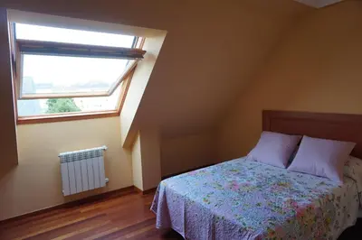 a bedroom with a bed and a window at Duplex Ribadeo in Ribadeo