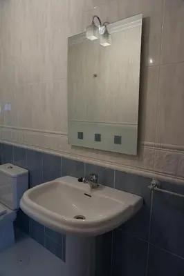 a bathroom with a sink and a mirror and a toilet at Duplex Ribadeo in Ribadeo