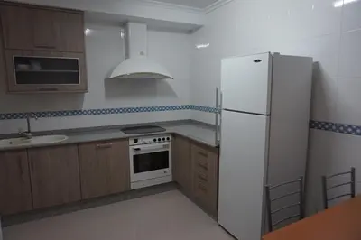 a kitchen with a white refrigerator and a sink at Duplex Ribadeo in Ribadeo