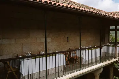 a balcony of a building with a bunch of birds on it at Casa Rural Rectoral de Armariz in Nogueira de Ramuin