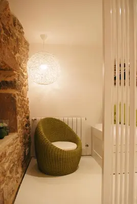 a bathroom with a large wicker chair in a room at Green Home in Santiago de Compostela