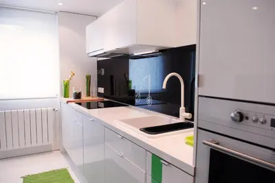 a white kitchen with a sink and a refrigerator at Green Home in Santiago de Compostela