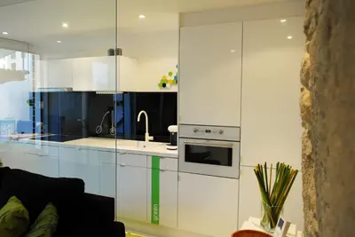 a kitchen with white cabinets and a stove top oven at Green Home in Santiago de Compostela