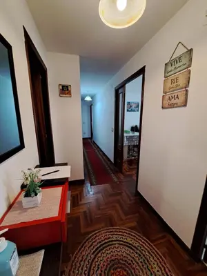 a living room with a red bench and a sign on the wall at Piso Mónica in Ribadavia