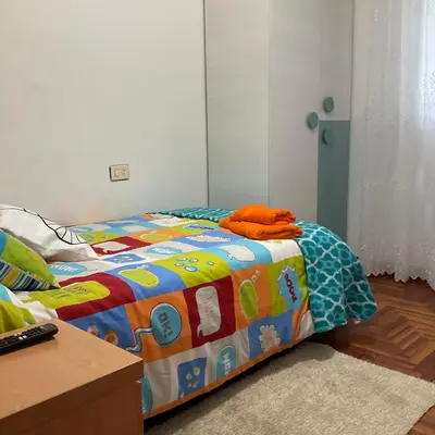 a bedroom with a bed with a colorful comforter at Piso Mónica in Ribadavia