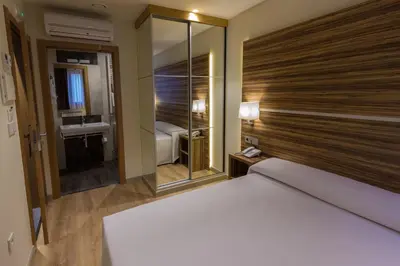 a bedroom with a large bed and a large mirror at Hotel Novo Cándido in Ourense