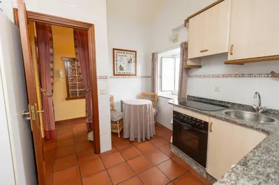 a kitchen with a sink and a stove at Escuder Apartamentos Turísticos in Ribadeo