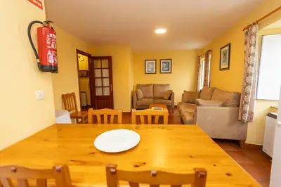 a living room with a wooden table and a couch at Escuder Apartamentos Turísticos in Ribadeo
