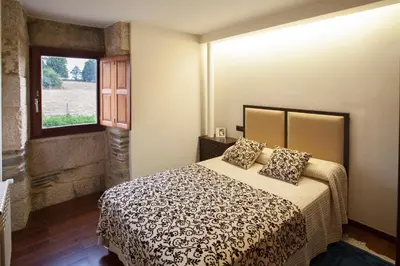a bedroom with a bed and a window at Casa Do Bosque in Sarria