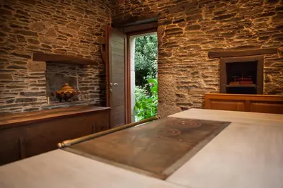 a bed in a room with a stone wall at Casa Do Bosque in Sarria