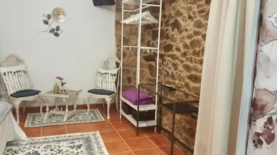 a room with two chairs and a table and a wall at A Casiña de Esther in Teo