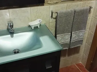 a bathroom with a sink and two towels at A Casiña de Esther in Teo