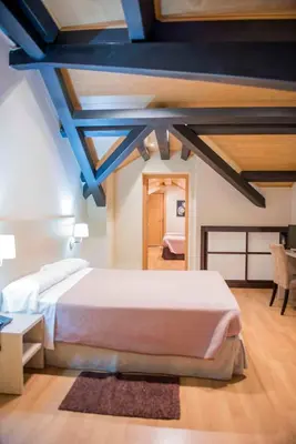a bedroom with a large white bed in a room at Hotel Meson de Erosa in Herosa