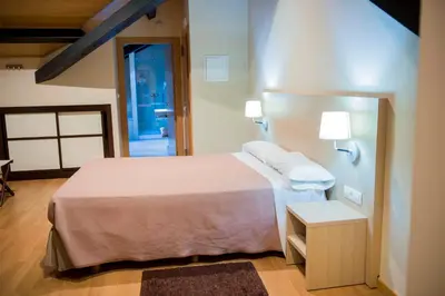 a bedroom with a bed with two white towels on it at Hotel Meson de Erosa in Herosa