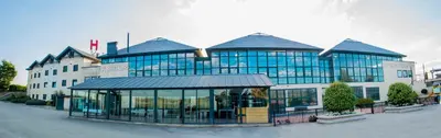 a large building with glass windows in front of it at Hotel Meson de Erosa in Herosa