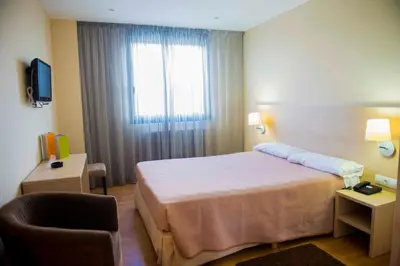 a hotel room with a bed and a window at Hotel Meson de Erosa in Herosa