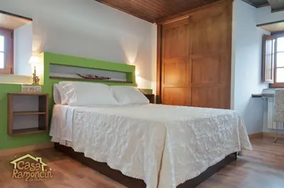 a bedroom with a bed with a white bedspread at Apartamentos Casa Ramoncín in A Pontenova
