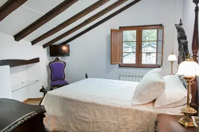 a bedroom with a large white bed and a window at Apartamentos Casa Ramoncín in A Pontenova