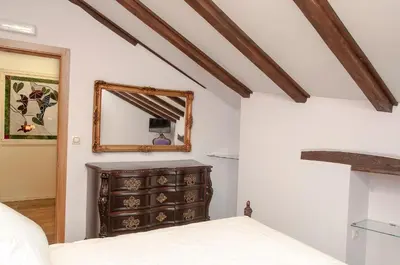 a bedroom with a dresser and a mirror at Apartamentos Casa Ramoncín in A Pontenova