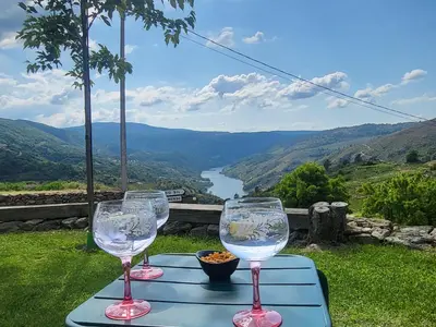 two wine glasses on a table with a view of a river at Casa Grande de Cristosende in Cristosende