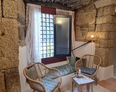 a room with two chairs and a window at Casa Grande de Cristosende in Cristosende
