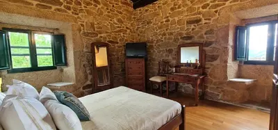 a bedroom with a bed and a desk in a room at Casa Grande de Cristosende in Cristosende