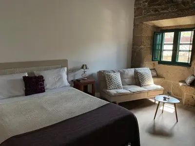a bedroom with a bed and a couch at Casa Grande de Cristosende in Cristosende