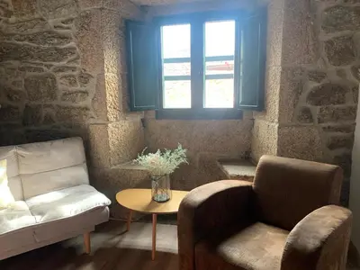 a living room with a couch and a chair and a table at Casa Grande de Cristosende in Cristosende