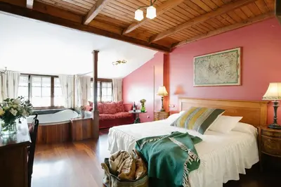 a bedroom with a bed and a bath tub at La Moncloa de San Lazaro in Cacabelos